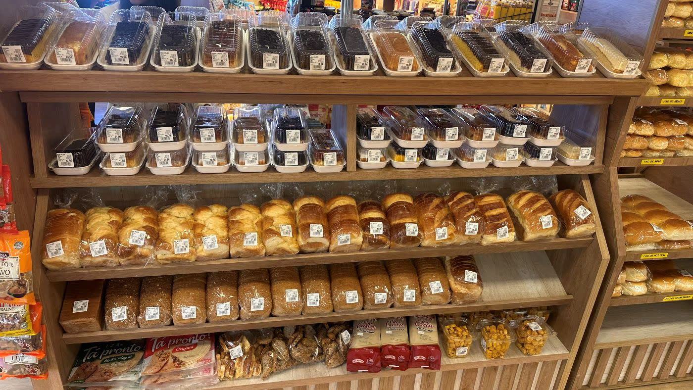 Estante de pães de forma, bolos caseiros e produtos de padaria embalados