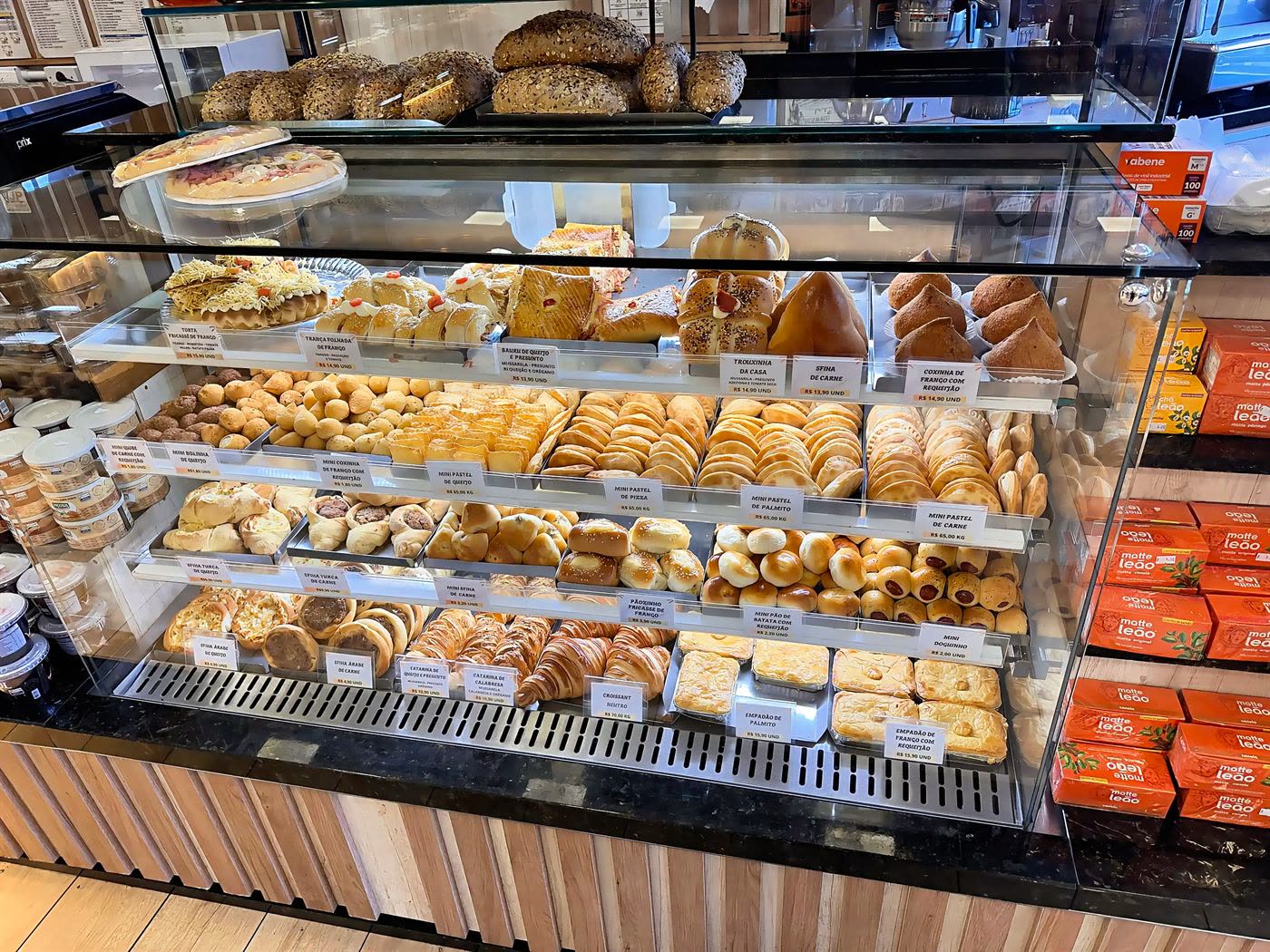 Vitrine de salgados com coxinhas, sfihas, mini pastéis, croissants e empadões