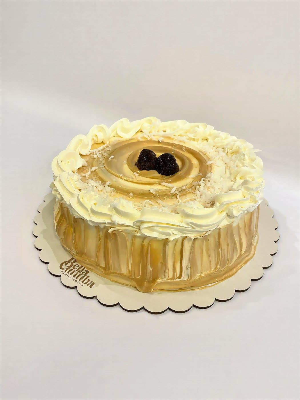 Torta decorada com chantilly, calda de doce de leite, coco e ameixas