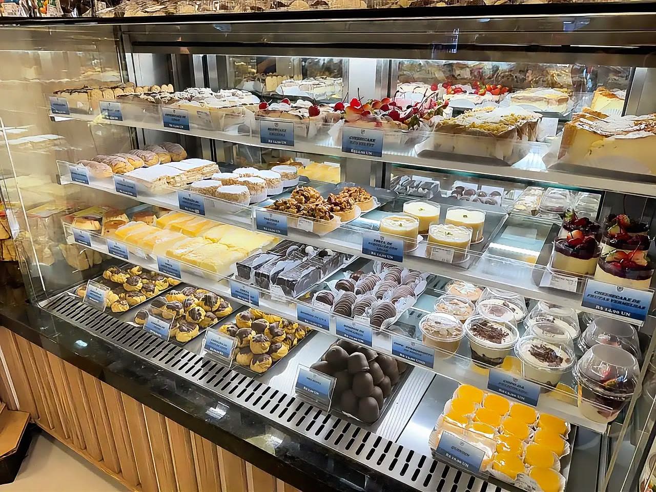 Vitrine de confeitaria com tortas, cheesecakes, bombons e doces variados