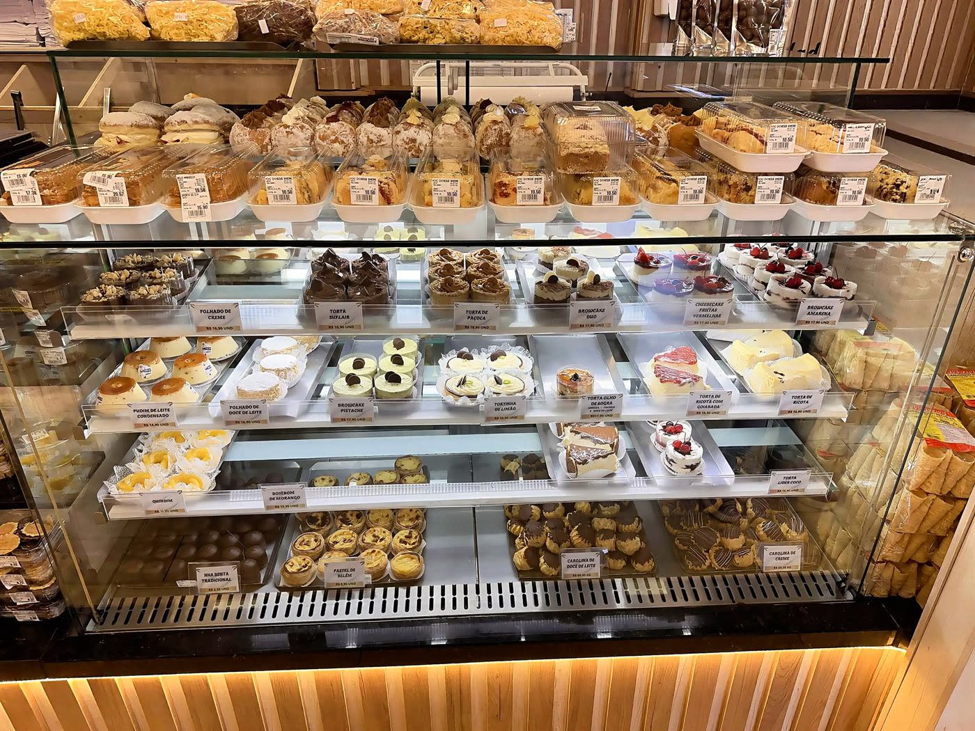 Vitrine de doces com pudins, folhados, quindins e pastéis de Belém